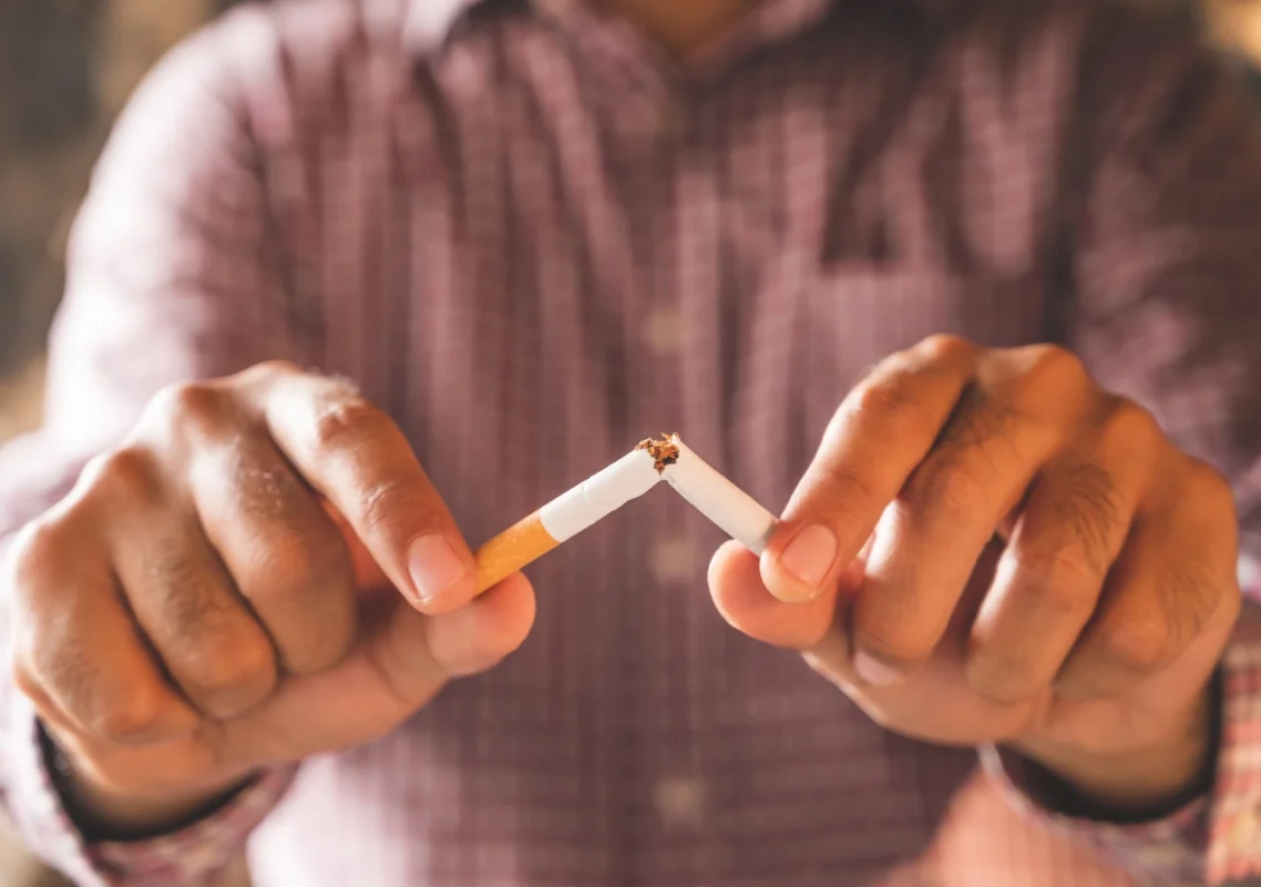 Čovek lomi cigaretu na pola Shopex.rs