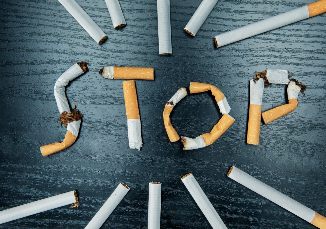izlomljene cigarete i njima ispisana reč stop